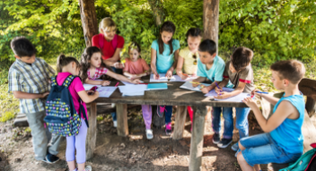 School kids colouring on a field trip