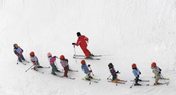 School children skiing with ski instructor