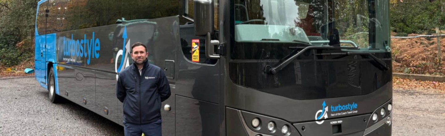 Driver stood next to Turbo style coach