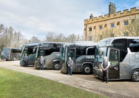 Readybus luxury coaches lined up outside a historic building with professional drivers, providing premium coach hire services in London and the South East